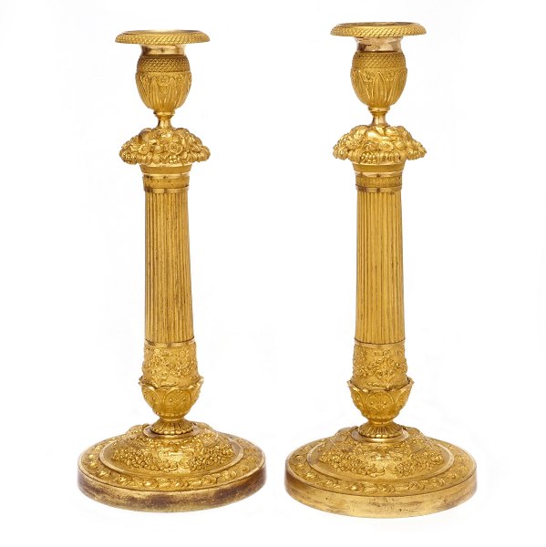 Par lueforgyldte bronze lysestager med kannelerede stammer. Rigt dekoreret med 
stiliserede blomster og bladværk. Frankrig ca. år 1820. H: 34cm