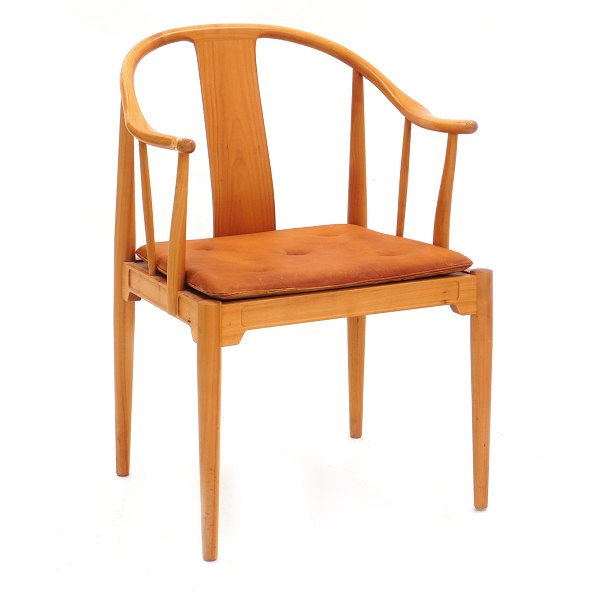 Hans Wegner Kina stole. Hans J. Wegner, 1914-2007, Kinastole i lyst kirsebærtræ 
med patineret hynde i cognacfarvet læder.